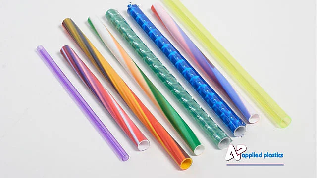 Row of extruded plastic tubes in solid, striped and swirled colors