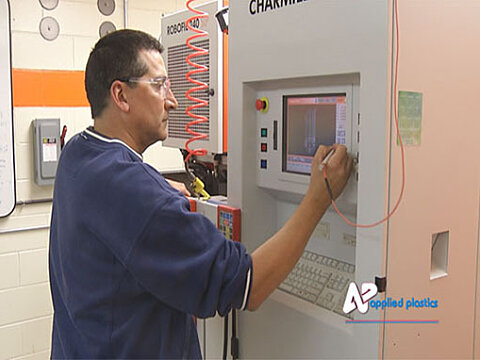 A toolmaker setting up a wire EDM machine