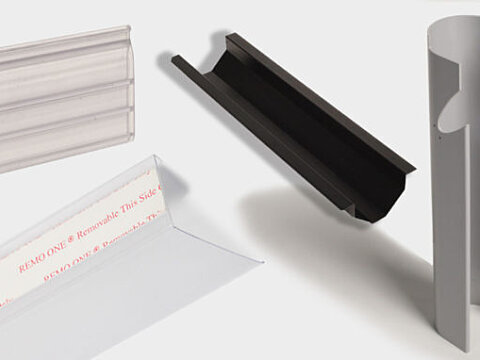 Extruded plastic profiles: a clear label holder, a black channel and a white radiused panel
