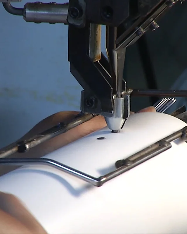 Machine head drilling a hole in a white plastic tube